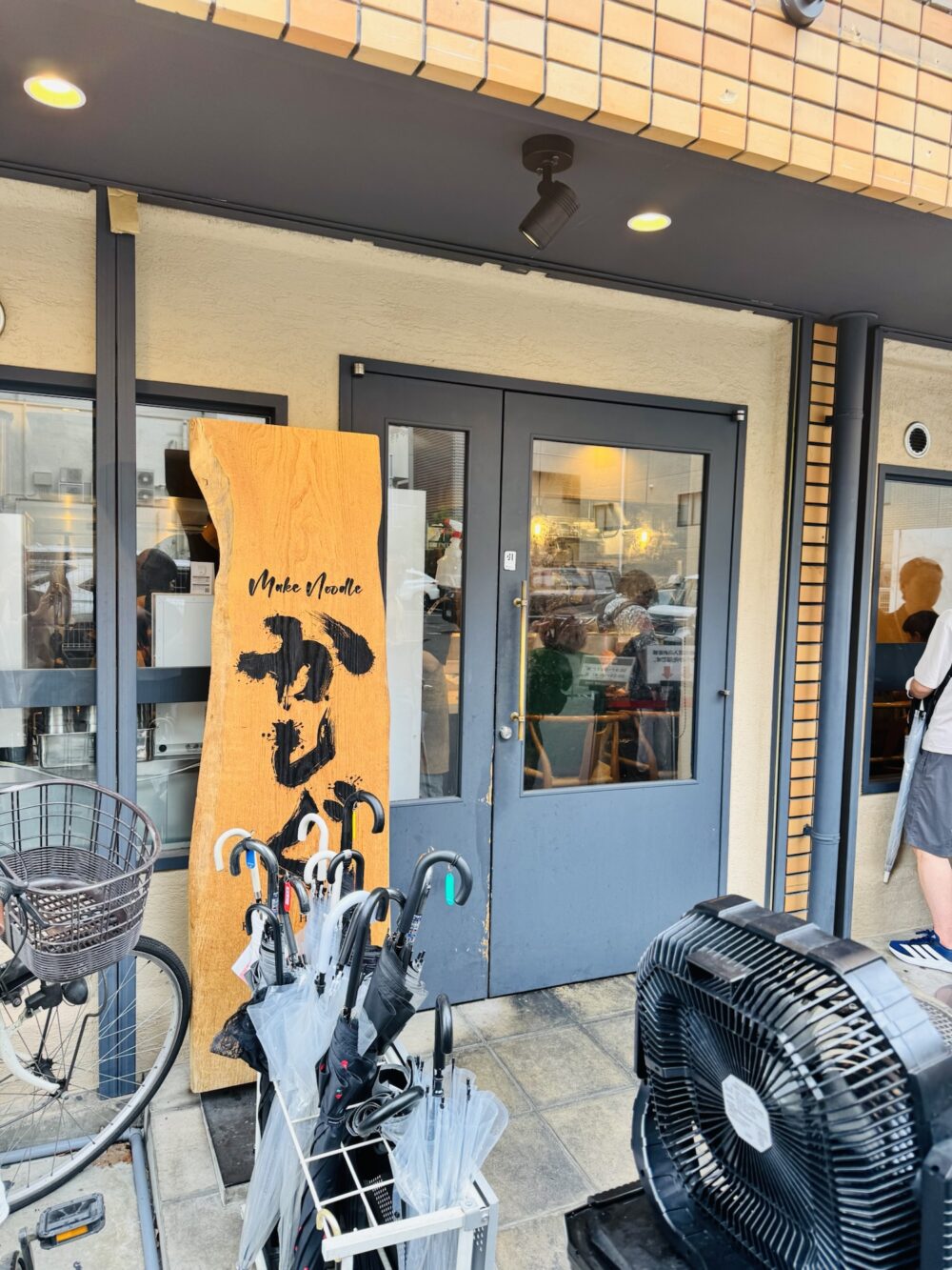 江坂のmake noodle かしぐの店舗外観と木の看板